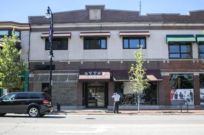 Angel Reyes with the DeKalb Police Department takes pictures of the front of the shuttered Otto's building along Lincoln Highway in downtown DeKalb during an investigation of the building July 31, 2015. The owner of the former nightclub building has been ordered to pay the bank almost $470,000 for failing to maintain the property. The city is seeking a court order to demolish the building because it is a safety concerns.