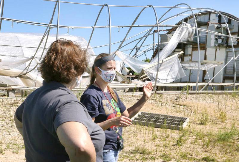 Jackie DiNatale, (left) communications director of DeKalb County Community Gardens, and Heather Edwards, associate director of DCCG, talk Tuesday, Aug. 11, 2020, in front of the greenhouse destroyed in Monday's storm at the The DeKalb County Community Gardens' Walnut Grove Vocational Farm in Kirkland. Along with the greenhouse the farm sustained other damage in the storm including dead plants, downed trees and broken outdoor furniture. Whether the devastation occurred due to a tornado or a derecho packing strong straight-line winds is yet to be determined.