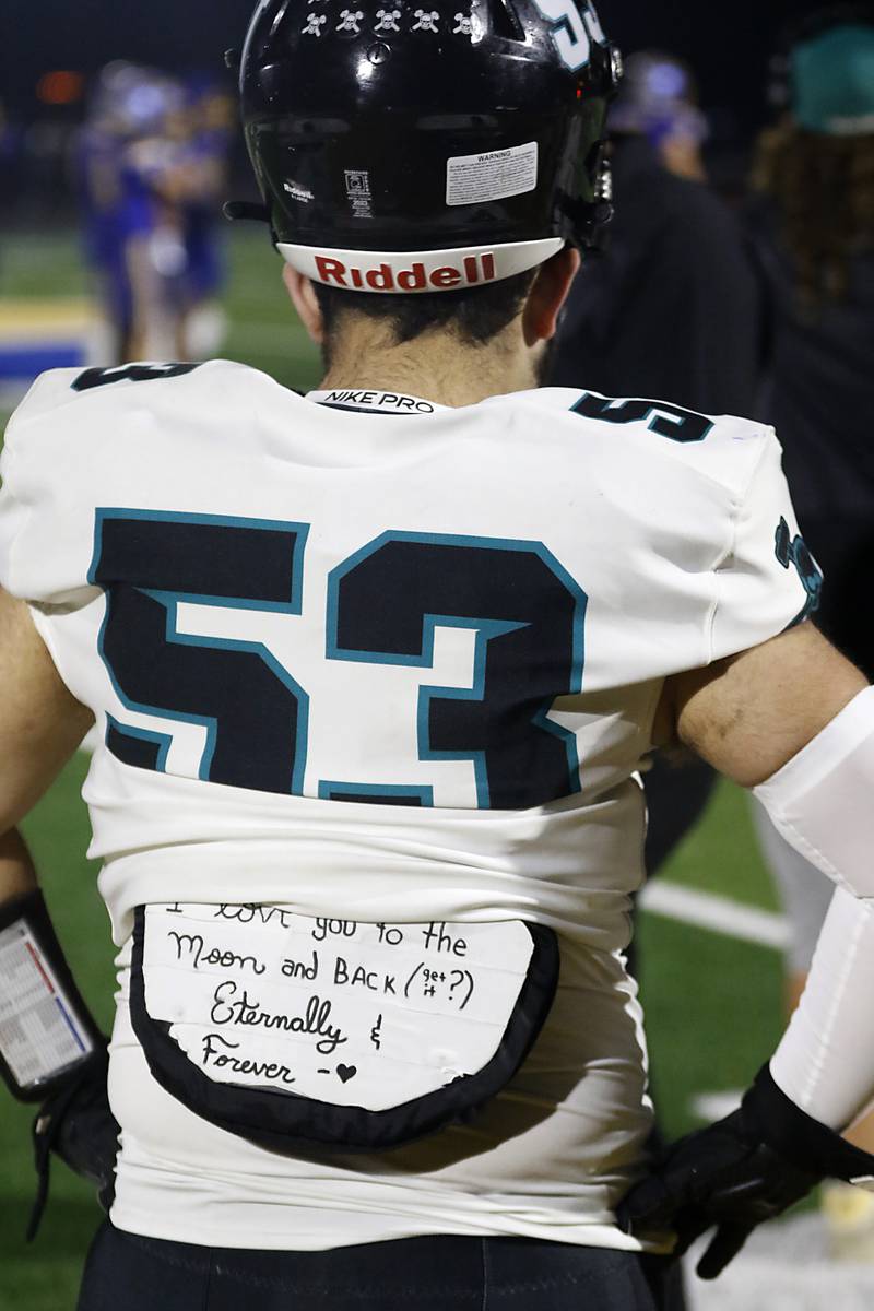 Woodstock North's Reid Verastique wears a message on his pads during a Kishwaukee River Conference football game against Johnsburg on Friday, Sept. 26, 2025, at Johnsburg High School.