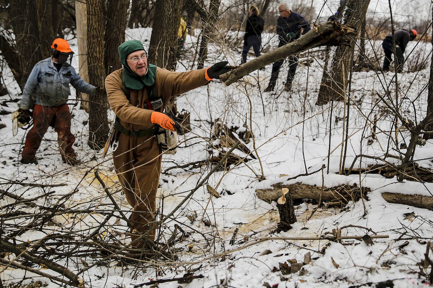 Dave Wendt of Joliet tosses a log as he volunteers at the Rock Run Forest Preserve in Joliet on Monday. Volunteers helped remove brush as part of the Martin Luther King Jr. Day of Service.