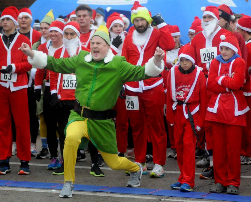 Chris Christensen, dressed as Buddy the Elf, fires up the runners before the start of the McHenry County Santa Run For Kids