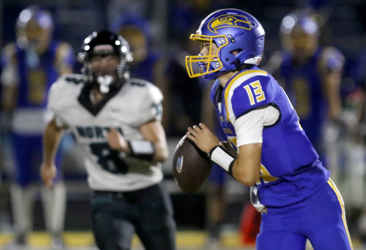 Johnsburg's Carter Block looks to pass as Woodstock North's Michael Pintor runs towards him during a Kishwaukee River Conference football game on Friday, Sept. 26, 2025, at Johnsburg High School.
