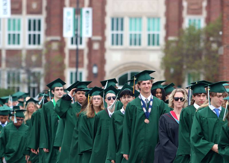 Members of the Class of 2025 march to the stadium for graduation at York High School in Elmhurst on Sunday, May 18, 2025.