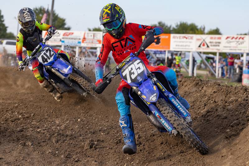 Motocross racer Brackyn Massie (735) battles Eddie Martens (412) to defend his position during Megacross at the Tri County Fair on August 30, 2025 in Mendota.