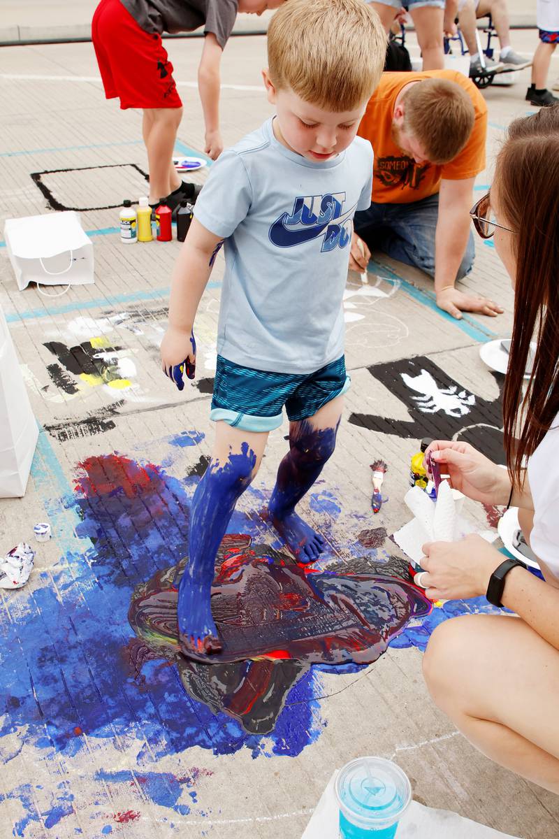 Waylon Lebarron, 4, of Tampico showing a real artist doesn't need paint brushes when they have their feet. Waylon was one of many young artists fully enjoying themselves Saturday, Sept. 20, 2025, at Morrison's Paint the Town event.