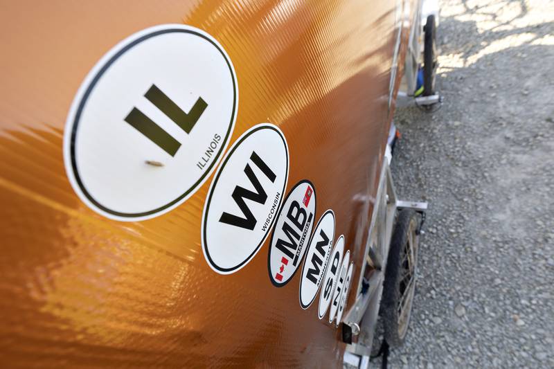 A list of stickers keeps track of his hikes as seen Friday, Aug. 15, 2025. Hickle also has maps of previous and current hikes posted to his wagon.