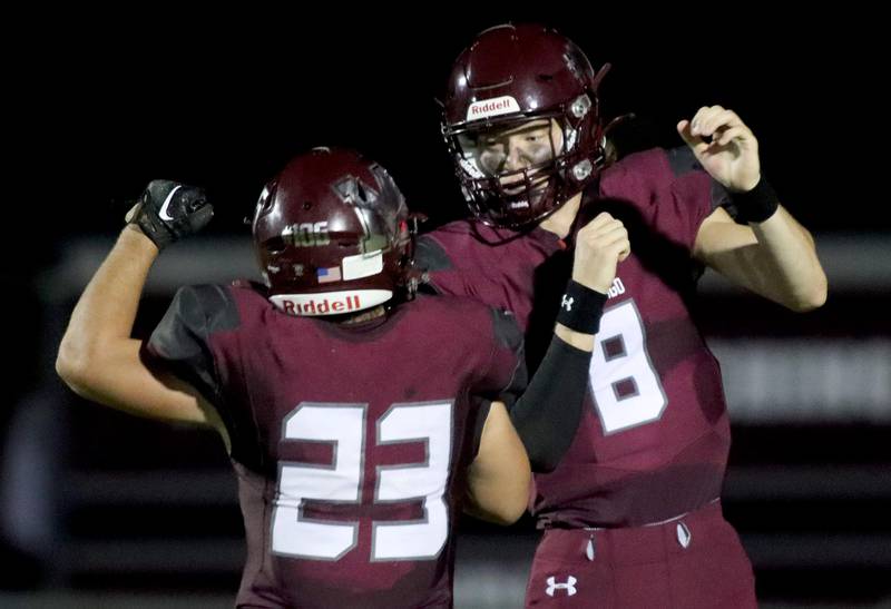 Marengo’s Josh Holst (right) is greeted by Joseph Leibrandt after a touchdown against Johnsburg on Friday, Sept. 17, 2022 in Marengo.