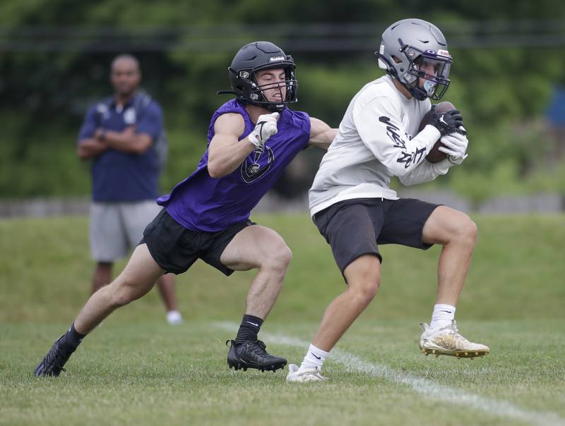 Downers Grove North’s Jimmy Carroll, left, pursues Oswego East’s Tyler Dubiel during the Downers Grove South 7-on-7 in Downers Grove on Saturday, July 16, 2022.