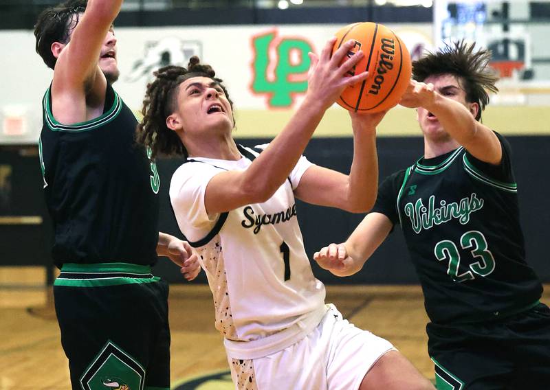 Sycamore's Josiah Mitchell goes to the basket between two North Boone defenders during their game Tuesday, Dec. 3, 2024, at Sycamore High School.