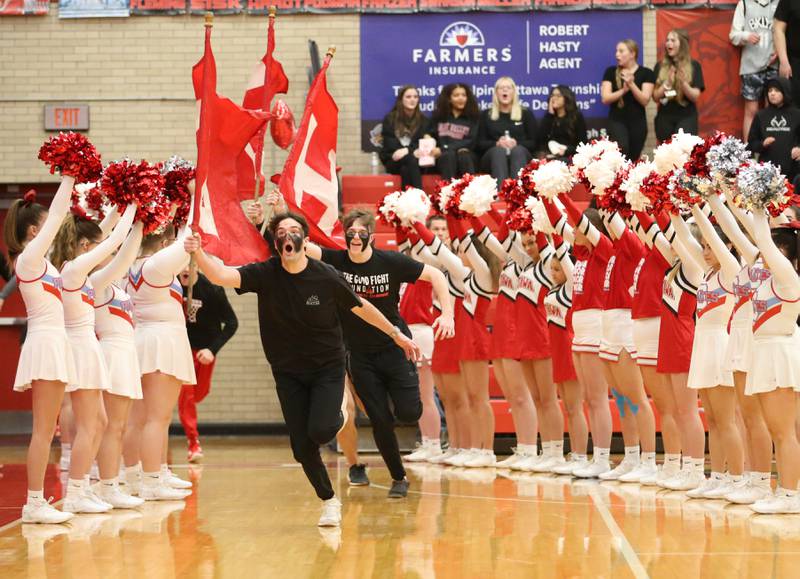 Superfans run through a tunnel of Ottawa High School cheerleaders before the game against L-P in Kingman Gymnasium on Friday, Feb. 10, 2023 at Ottawa High School.