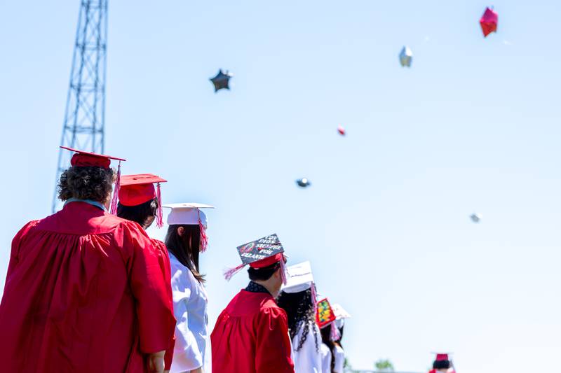Graduates watch balloons fly away on Sunday, May 18, 2025 at Hall High School in Spring Valley.