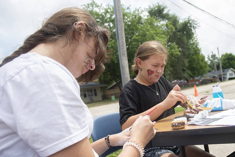 Jez’Liyn Hanson (left), 14, and Kendal Poff, 9, paint up their hands Thursday during a day of fun at the Coloma Homes in Rock Falls. The Whiteside County Housing Authority is sponsoring the end of summer fun to promote positivity and community awareness.