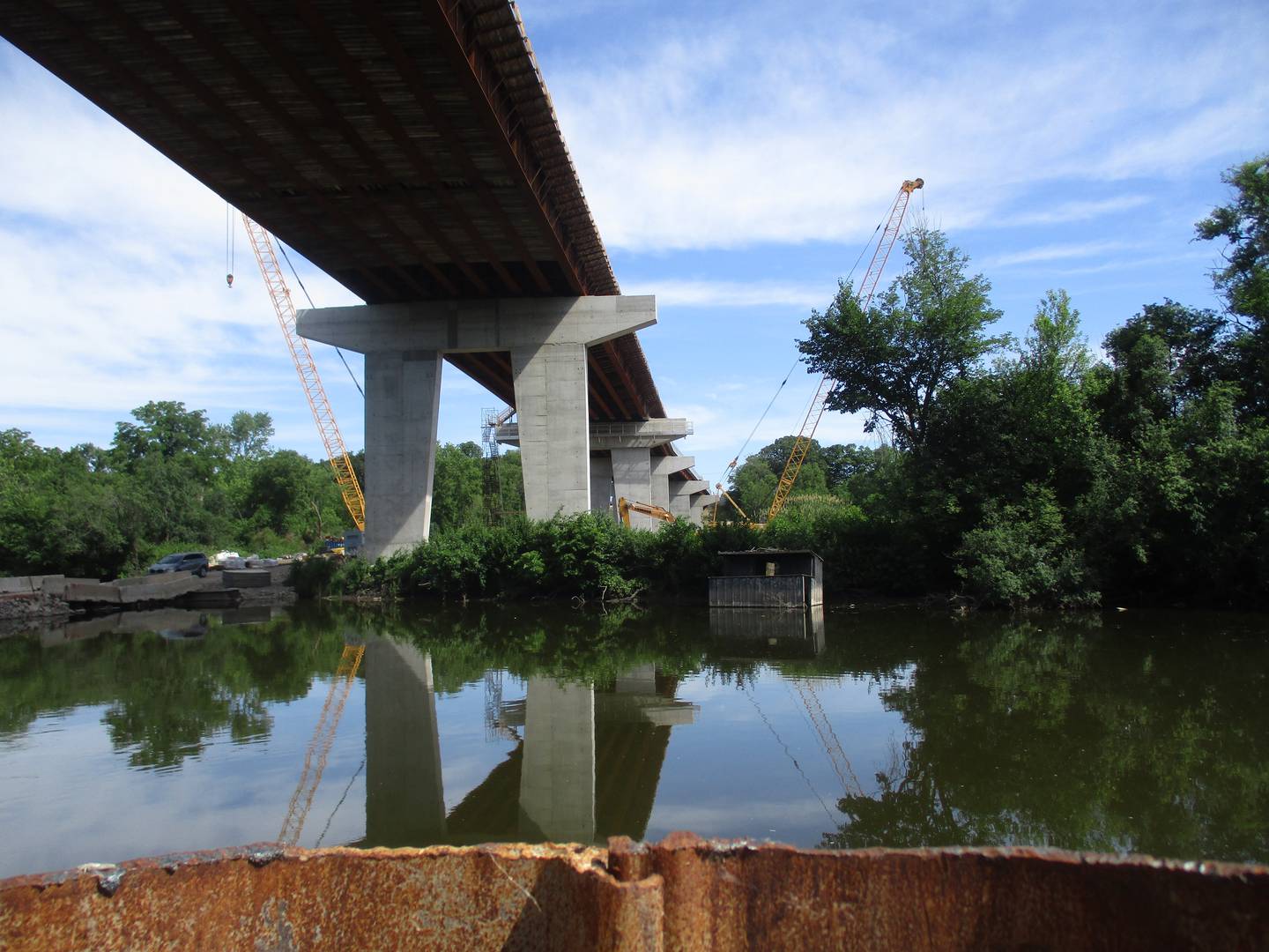 One of the giant concrete piers supporting the Eldamain Road bridge is reflected in the still waters created by a coffer dam used for the construction project. (Mark Foster -- mfoster@shawmedia.com)