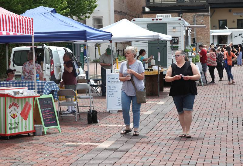 Patrons shop the booths and food trucks during opening day for the DeKalb Farmers Market Thursday, June 1, 2023, at Van Buer Plaza in downtown DeKalb. The Farmers Market is open every Thursday from 10 am to 2 pm through September 21.