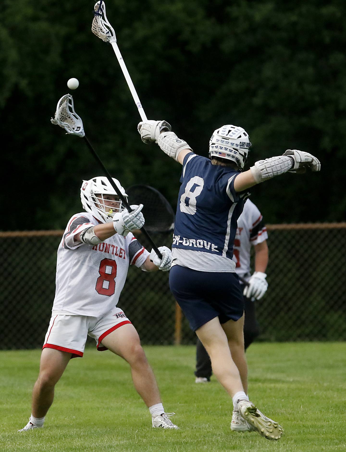 Huntley's Ryan Baumley passes the ball as Cary-Grove's Henry Kaiser tries to block the throw during the Marian Central Sectional boys lacrosse semifinal match on Wednesday, May 28, 2025, at Marian Central High School in Woodstock.