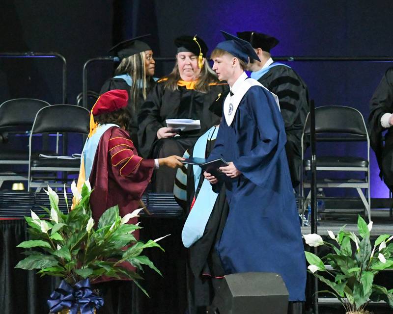 Oswego East senior Matthew Colwell receives his diploma on Saturday May 17, 2025, during the graduation ceremony held at the Convocation Center in DeKalb.