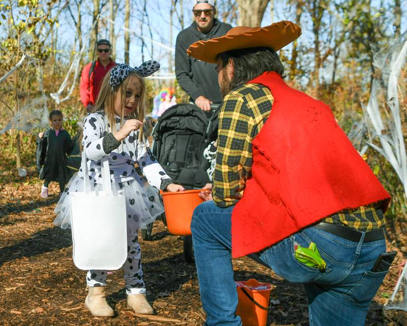 Palmer Englud, 3, of Glen Ellyn receives candy during the Boo Bash trail even on Saturday Oct. 26, 2024, held at Ackerman Park in Glen Ellyn.