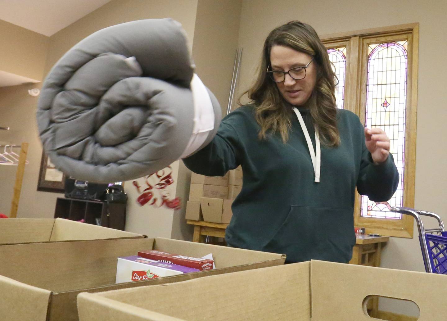 Jill Boedighimer places a blanket inside a baskets on Thursday, Dec, 14, 2023 at the Putnam County Food Pantry in Granville.  In collaboration with Toys in the Pantry, organizations, businesses, churches and schools from across the county the pantry is distributing Christmas baskets to local families in need. This is the 36th year the pantry has sponsored the basket project. The baskets contain food and gifts for children and senior citizens.