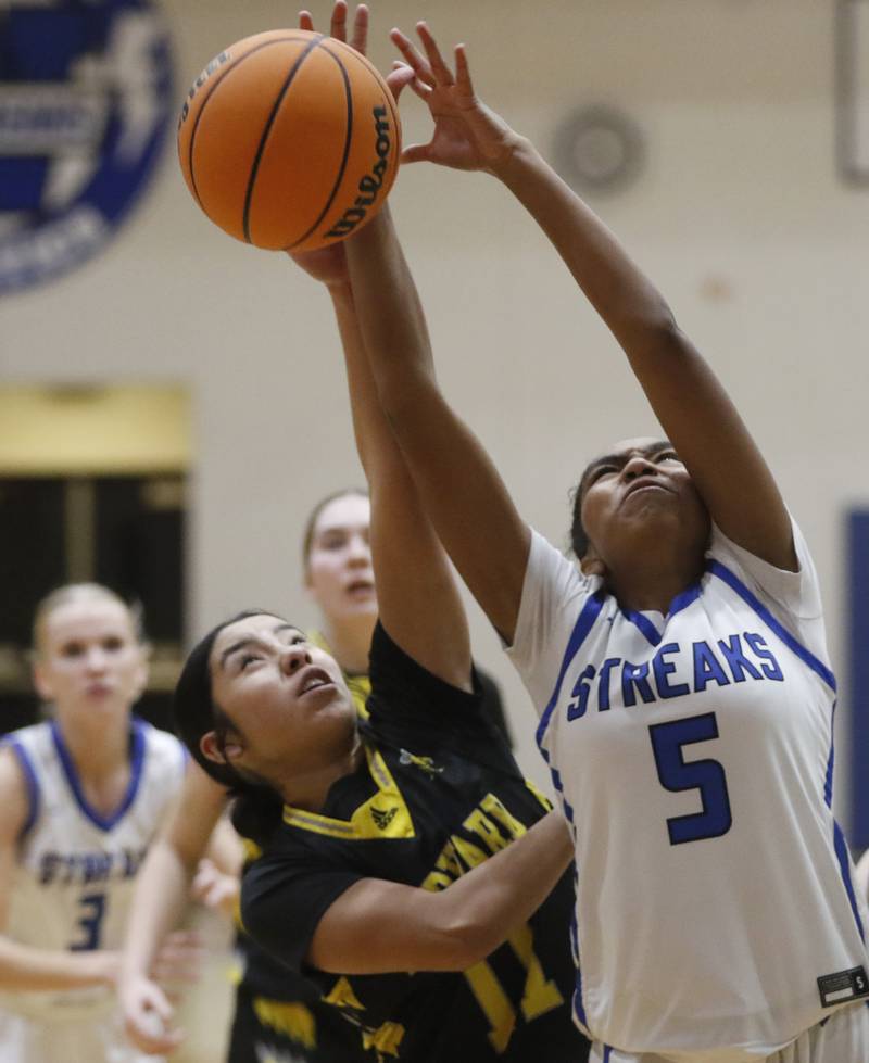 Harvard's Melissa Sanchez battles with Woodstock's Salome Freites-Alvarado for a rebound during a Kishwaukee River Conference girls basketball game on Monday Jan. 12, 2026, at Woodstock High School.