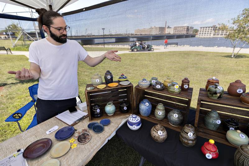 Nic Swanson talks about the pottery he has on display Saturday, August 23, 2025, at the Art in the Park sculpture walk in Rock Falls.