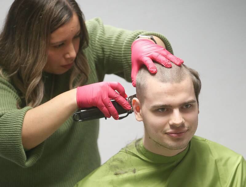 Beautician Erika Reyes shaves the head of Aaron Noble during the first ever St. Baldrick's event on Wednesday, April 30, 2025 at Illinois Valley Community College. This was Martin's first hair cut in over 5 years. Noble raised over $600 for the foundation.