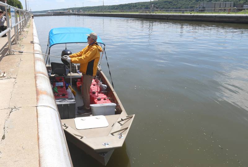 71 year old adventurer and thyroid cancer survivor Robert Youens, holds on to a rope while locking through the Starved Rock Lock and Dam on Monday, July 28, 2025 near Utica. Youens is making  the Great Loop, a 6,000 mile journey on his Jon boat something that hasn't been done before. Youens is looking at setting a record for the longest someone has gone on a Jon boat.