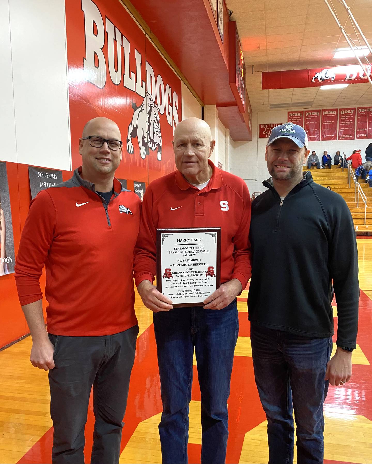 Longtime Streator assistant coach Harry Park (center) is flanked by sons Bryan and Brad on Friday, Jan. 20, 2023, after being honored for 41 years helping the boys basketball program.