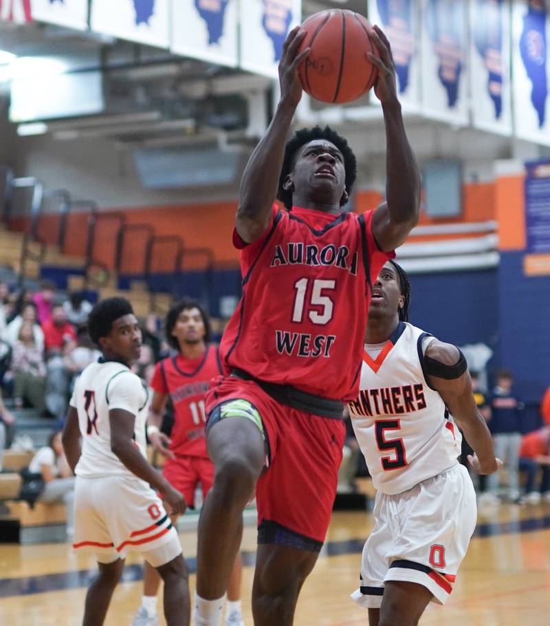 West Aurora's Kewon Marshall (15) drives to the hoop against Oswego’s Tyrell Mays (5) during a basketball game at Oswego High School on Friday, Dec 1, 2023.