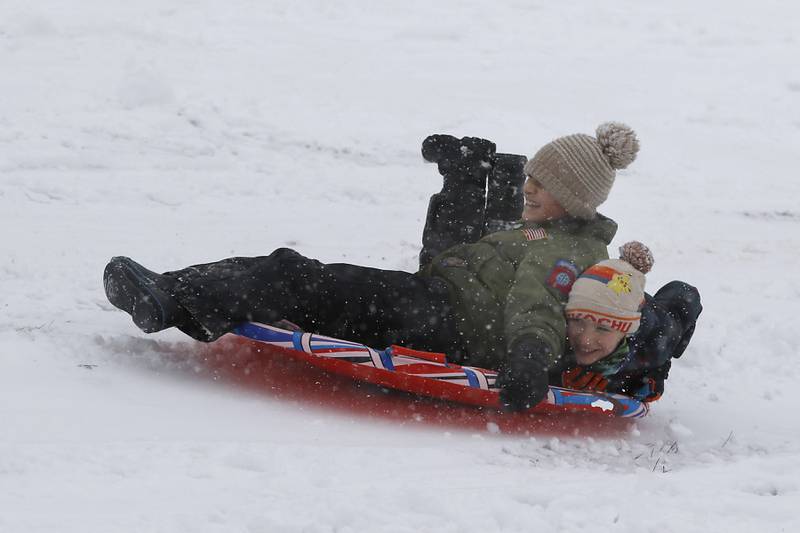 Anthony Domingo, 11, of Cary, and Henry Tuttle, 9, of Port Barrington, fly down the hill at Veteran Acres Park in Crystal Lake on Wednesday, Jan. 25, 2023, while sledding with other children. Snow fell throughout the morning, leaving a fresh blanket of snow in McHenry County.