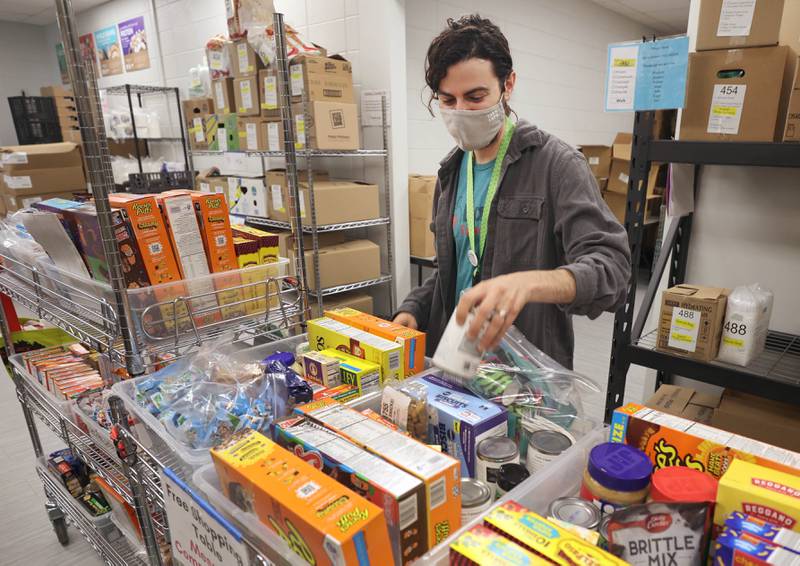 Frankie DiCiaccio, operations manager of Barb Food Mart, looks through the items on one of the shopping shelves Thursday, April 7, 2022, at the facility in DeKalb. Barb Food Mart is a food pantry serving those in need that have a student enrolled in the DeKalb School District.