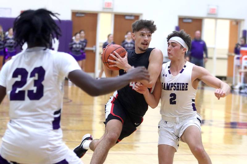 Huntley’s Ian Ravagnie, center, drives as Hampshire’s Joseph Costabile defends in boys basketball at Hampshire on Friday.