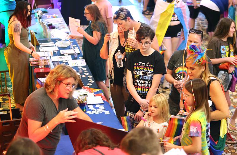 Visitors look at Pride related items set up on tables inside the Egyptian Theatre Thursday, June 23, 2022, during an event to celebrate Pride month. The function included a short parade through downtown and a showing of the movie “Tangerine,” with a panel discussion afterwards at the theatre.