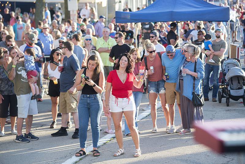 Friends, family and supporters of Gina Venier gather around the stage to hear the up and coming Nashville star Friday, July 1, 2022 at Dixon’s Petunia Fest.