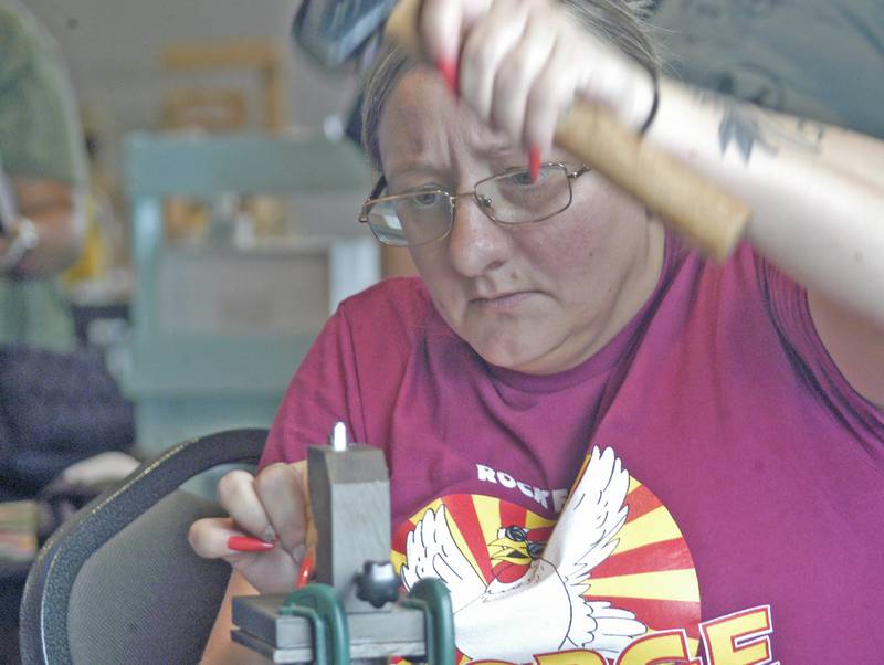 Tara Walker of B&T Jewelry in Sterling hand stamps a piece at the McCormick Event Center during George Fest in downtown Rock Falls on Saturday, July 26, 2025.