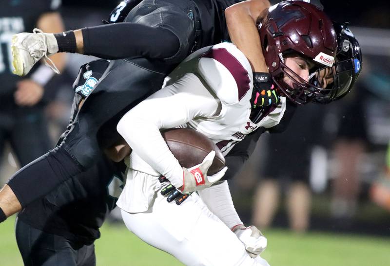 Marengo’s Parker Mandelky gathers a reception as he is hit by Woodstock North’s Adan Castaneda in varsity football at Rod Poppe Field on the campus of Marengo High School in Marengo on Friday, Sept. 12, 2025.