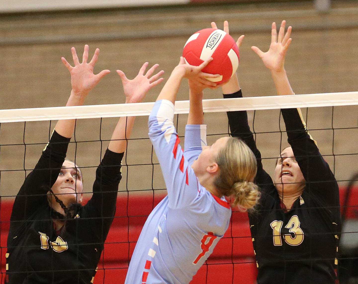 Ottawa's Skyler Dorsey sets the ball in the air as Morris's Aubrey Phillips and teammate Ava Smith try to hit it back over the net on Tuesday, Sept. 12, 2023 in Kingman Gym at Ottawa High School.