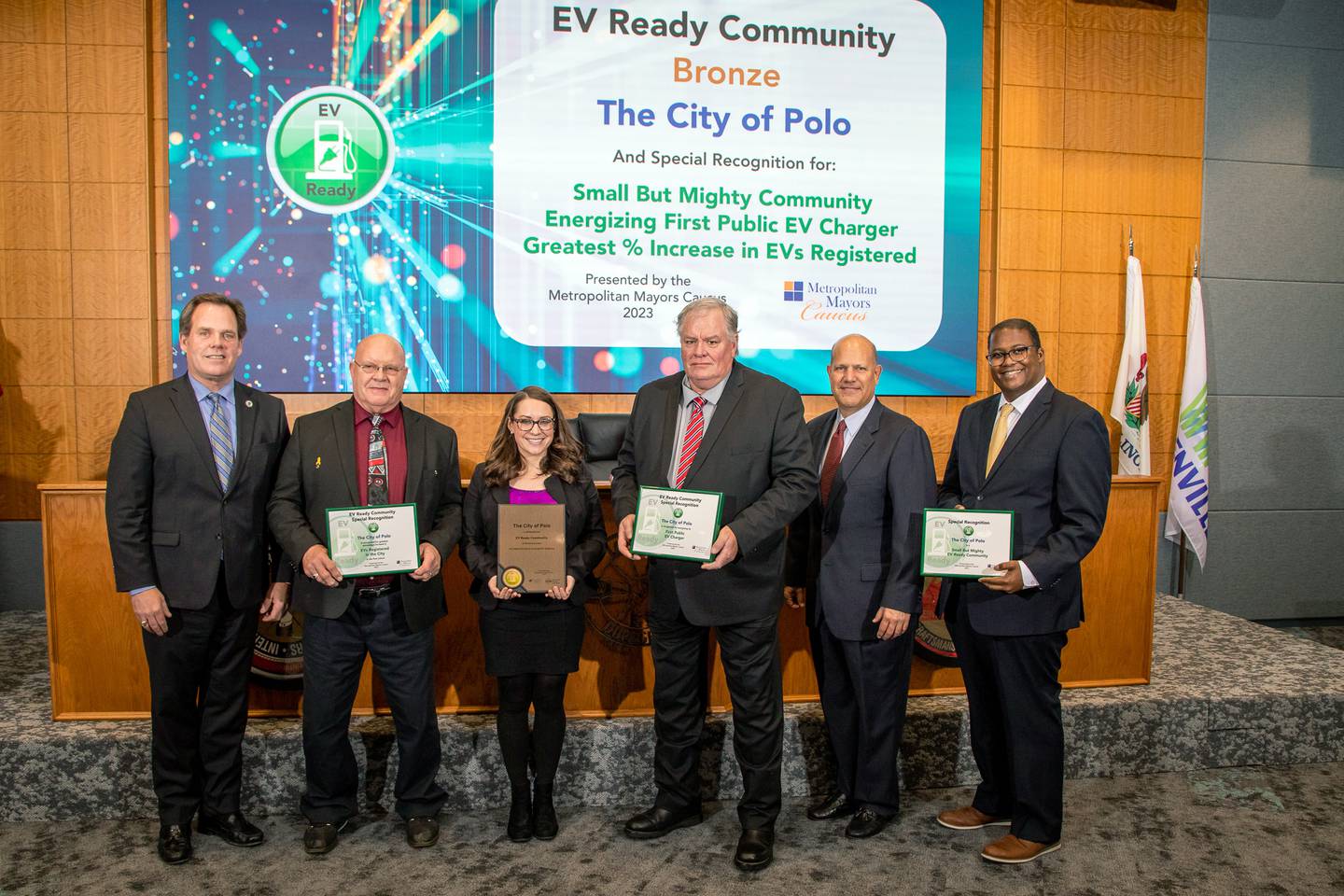 Polo Mayor Doug Knapp (second from left), City Clerk Sydney Bartelt (center left) and Polo Alderman and Ogle County Economic Development Corporation President Randy Schoon (center right) accept awards recognizing the work Polo has done to become ready for electric vehicles on Thursday, Dec. 7, 2023, in Warrenville. Also pictured, left to right, are: Kevin Burns, mayor of Geneva and chair of the Metropolitan Mayors Caucus' Environment Committee and Energy Subcommittee; Louie Binswanger, ComEd senior vice president of Governmental, Regulatory and External Affairs; and Neil James, Metropolitan Mayors Caucus executive director.