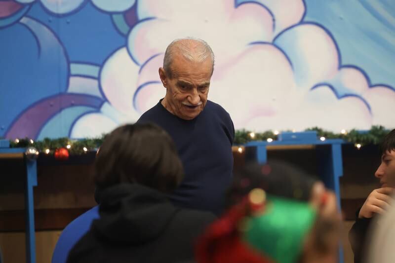 Volunteer Frank Bati talks with the kids at the Boys & Girls Club Joliet pizza party on Saturday, Dec.18, 2023.