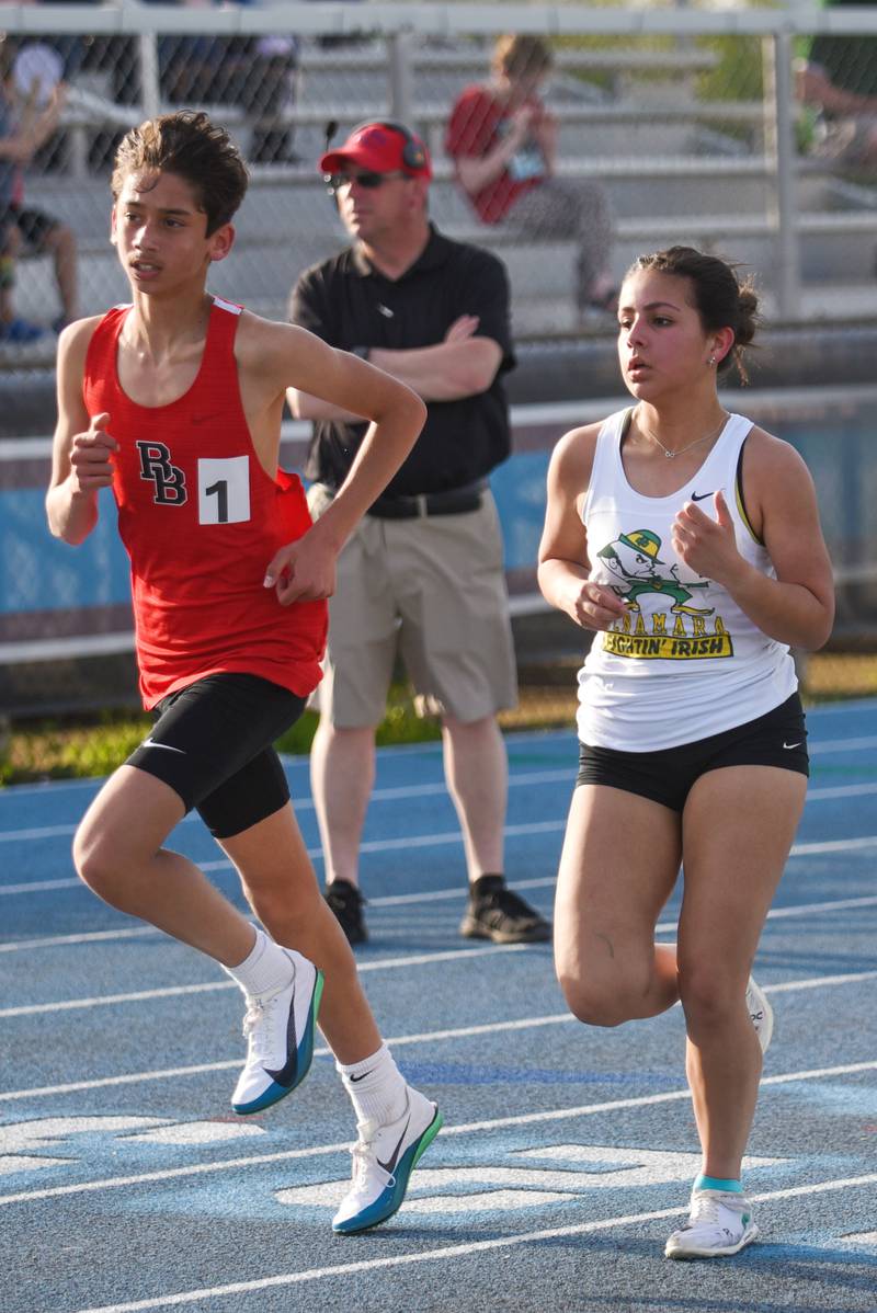 Bradley-Bourbonnais' Kyler Savini, left, and Bishop McNamara's Ana Franchescini run the 3,200 m race at the All-City track and field meet at Kankakee Monday, April 28, 2025.