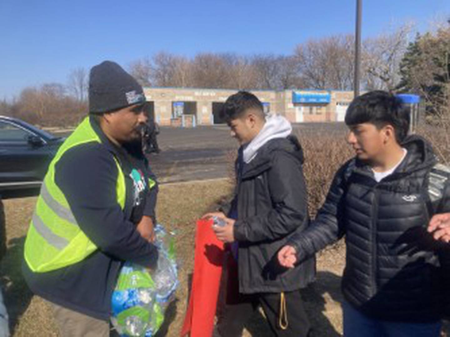 Jose E Vera, executive director of the Southwest Suburban Immigrant Project, hands out bottles of water to Bolingbrook High School students during a protest against Immigration of Customs Enforcement actions on Friday, Feb. 13, 2026. Hundreds of Bolingbrook students walked out of school to stage the protest.