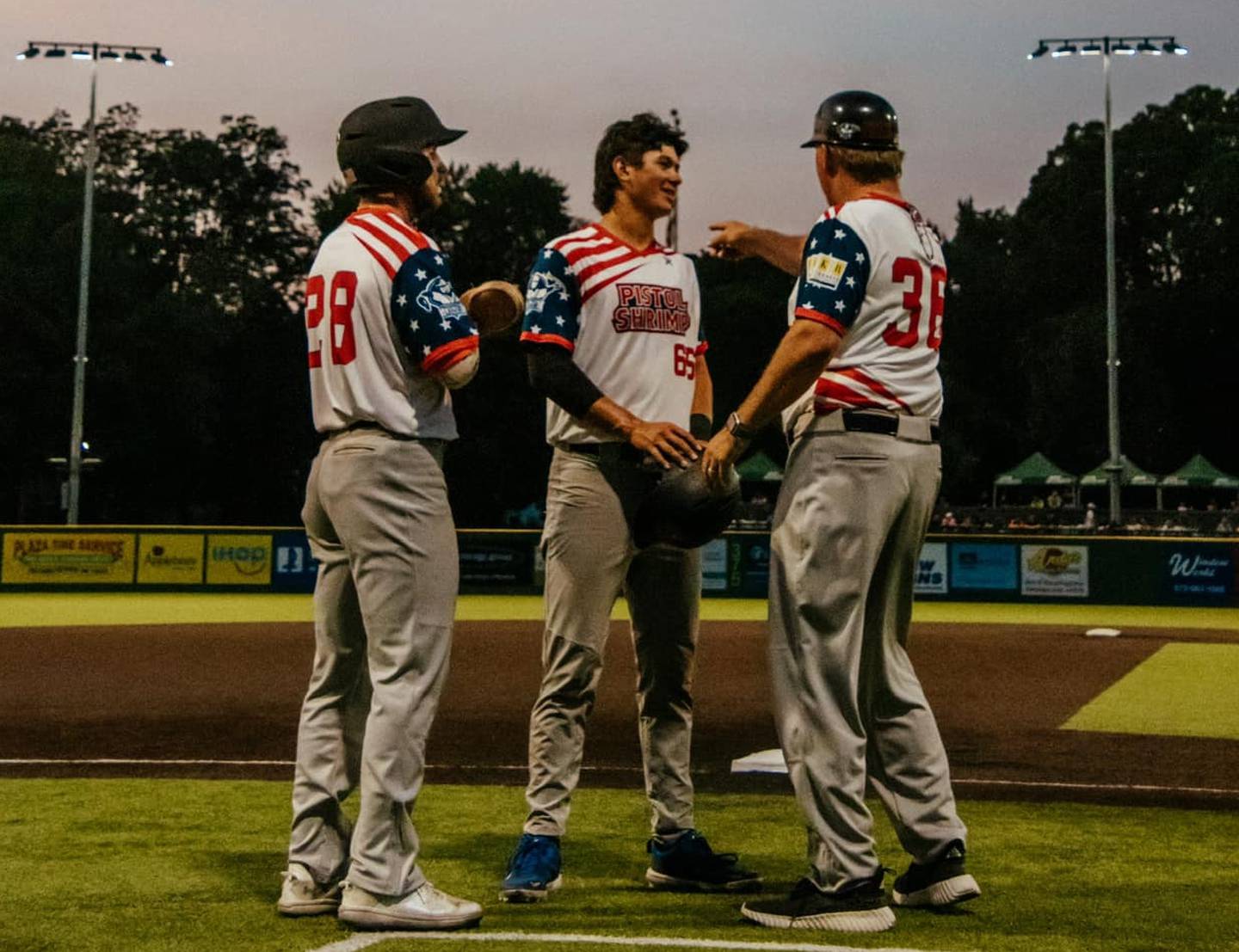 Illinois Valley's Tyler Dorsch (left) and Kyle Gibson (middle) talk with manager John Jakiemiec during the Illinois Valley Pistol Shrimp's 8-6 win over the Cape Catfish on Saturday, June 15, 2024 in Cape Giradeau, Mo.