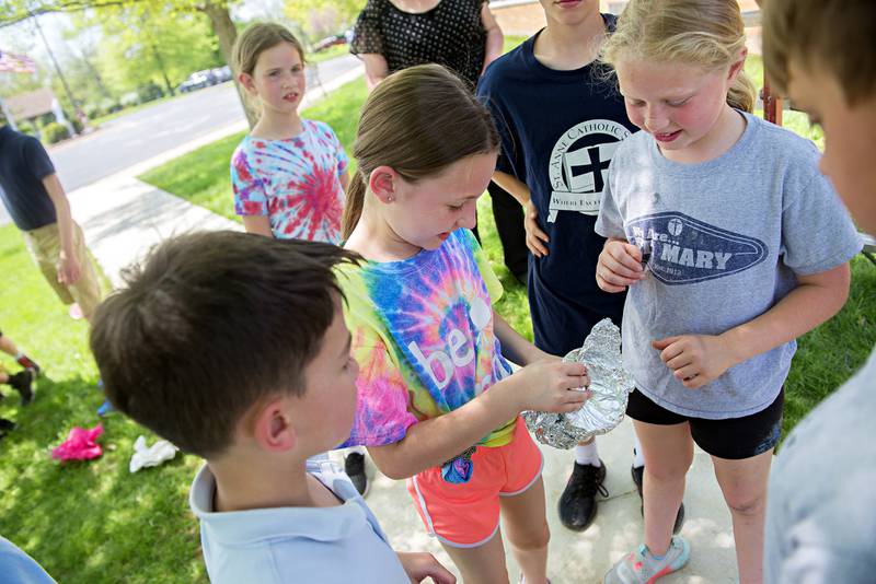 Rebecca Halgren, fourth grader at St. Anne’s School, opens up her team's egg protection after a drop test Friday at the school. The ovum survived both a drop on grass and concrete.