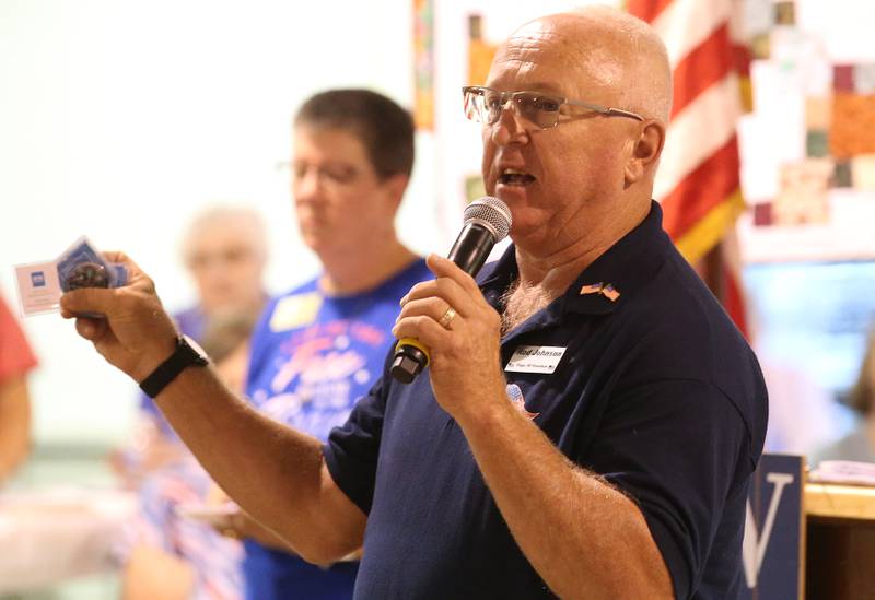 he Flags of Freedom Committee chairman Rod Johnson, hands out commemorative coins to Veterans during the Quilt of Valor Tribute to Veterans ceremony on Wednesday, Aug. 20, 2025 at the Bureau County Fair in Princeton.
