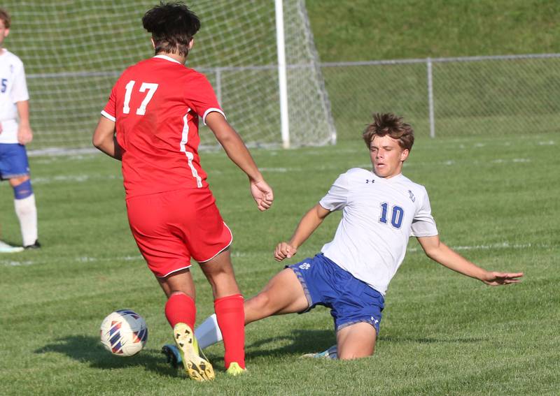 Princeton's Josh Orwig slides to kick the ball away from Ottawa's Alan Sifuentes on Tuesday, Oct. 3, 2023 at Ottawa High School.