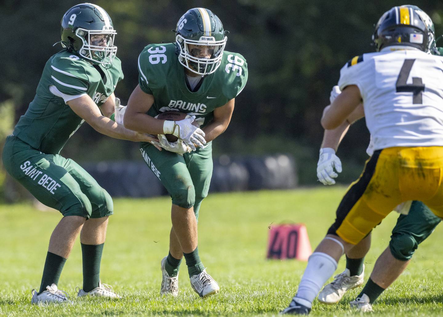 St. Bede's Max Bray hands the football off to Landon Marquez for a small gain of yards during the game against the Elmwood Park Tigers on September 30, 2023.