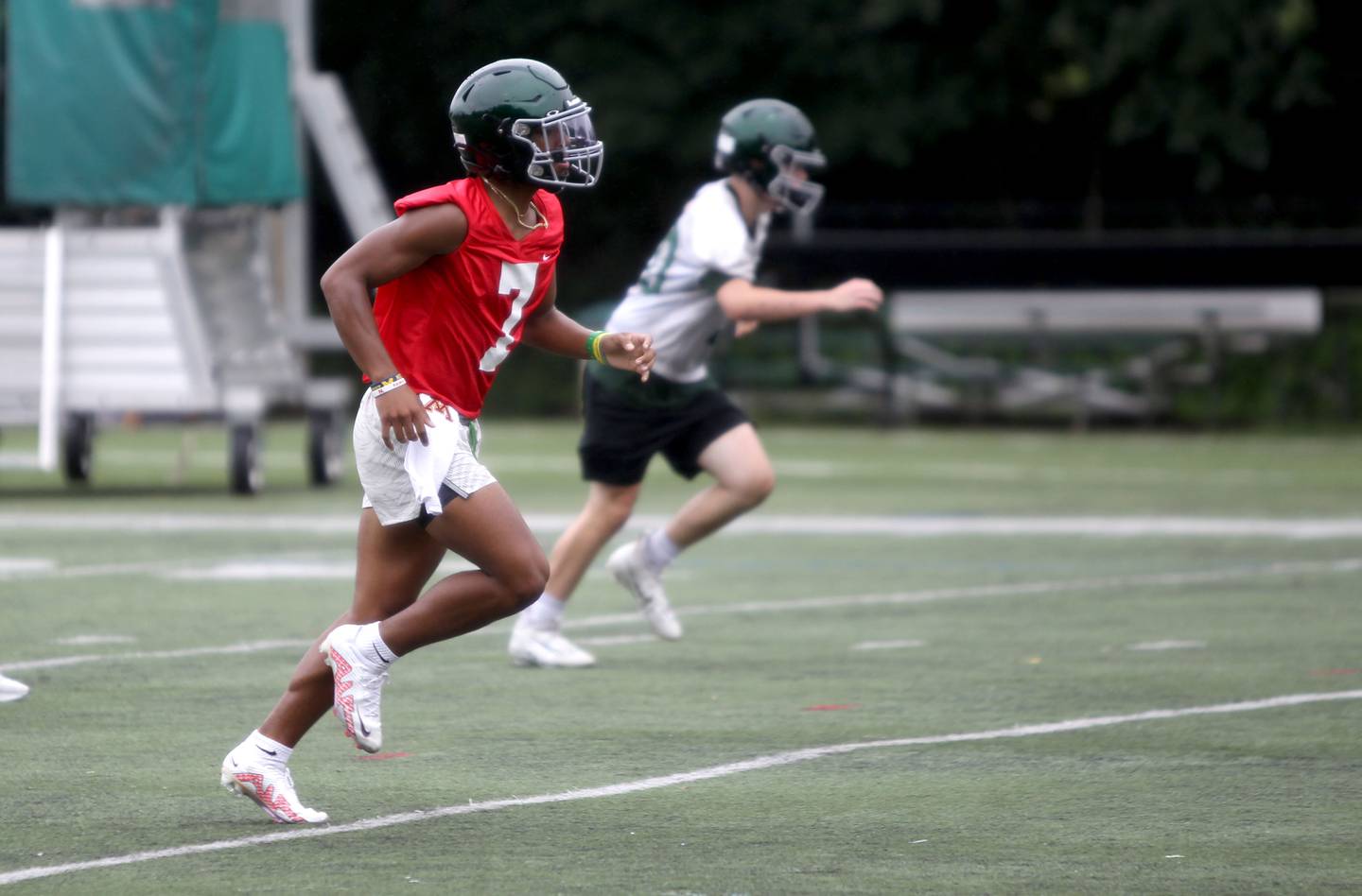 Glenbard West quarterback Korey Tai runs drills with his team during the first official day of practice in Glen Ellyn on Monday, Aug.  8, 2022.