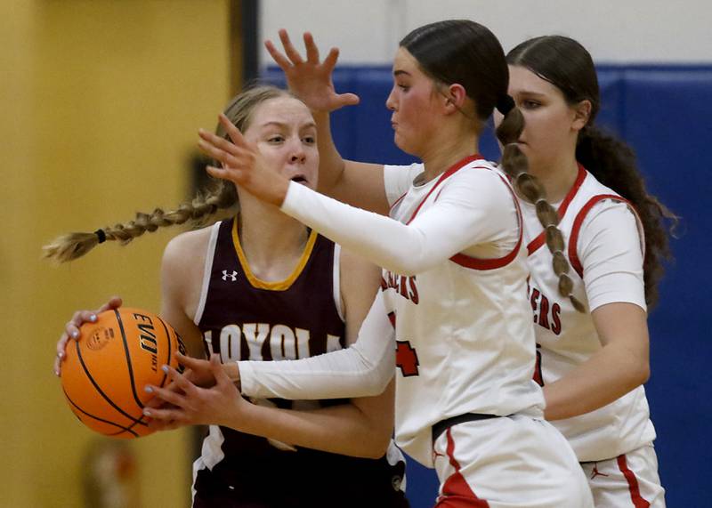 Loyola Academy's Emily Naraky tries to drive the ball against Huntley's Ava Mcfadden (center) and Paula Strzelecki (right) during the IHSA Class 4A Gurnee Warren Supersectional girls basketball game on Monday, March 3, 2025, at Warren Township High School in Gurnee.