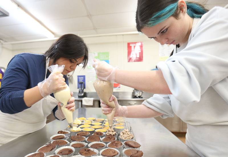 Area Career Center students Andrea Luasia and Madison Eldridge pipe frosting on chocolate and vanilla cupcakes at the Culinary Corner Cafe on Tuesday, Feb. 11, 2025 at La Sale-Peru Township High School. February is Career and Technical Education (CTE) month.  The month recognizes CTE programs and their contributions to preparing students for college and careers.