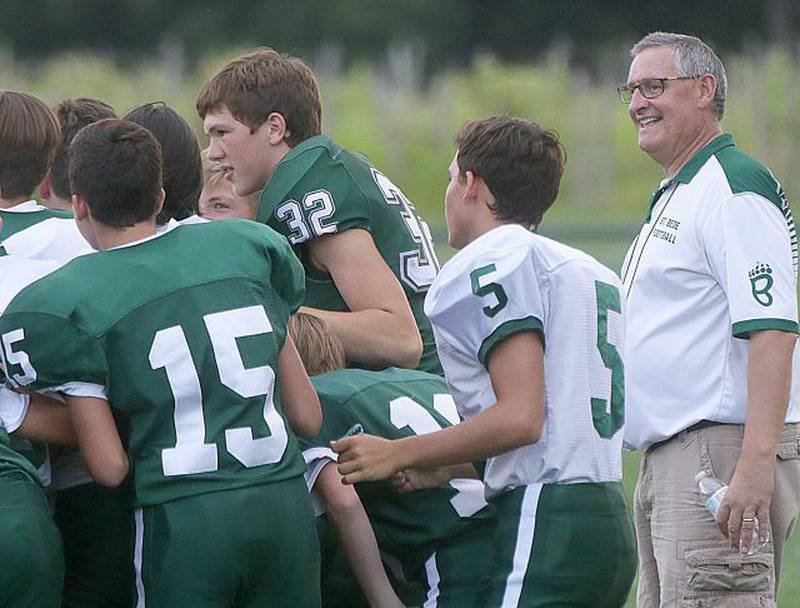 St. Bede football head coach Jim Eustice (right) smiles as he prepares his players for another season.