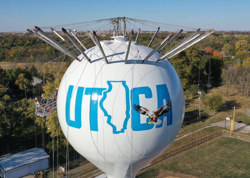 Crews paint the Utica water tower on Friday, Oct. 18, 2024 on top of Clarks Hill in Utica. The Village gave the approval to paint the tower and also conduct repairs inside and out. A Bald Eagle and the State of Illinois is featured on the tower.